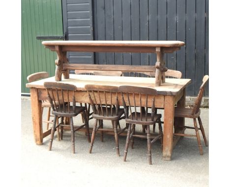 An antique pine dining table, 183 x 90cm, together with a pitch pine bench and nine spindle back dining chairs, with elm seat