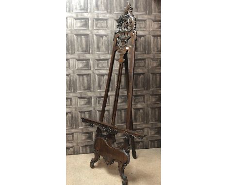 MAHOGANY EASEL, in the Victorian style, with carved top and supports, 105cm wide