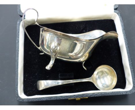 A silver cream jug and ladle in fitted case. Sheffield 1930
