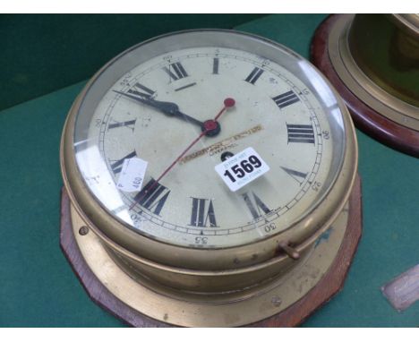 A vintage brass ship's bulkhead clock, 23cms together with a similar aneroid barometer 22.5cms