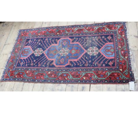 A North West Persian rug, the blue field with light blue lobed medallion and red meander border, 197 x 112cm.