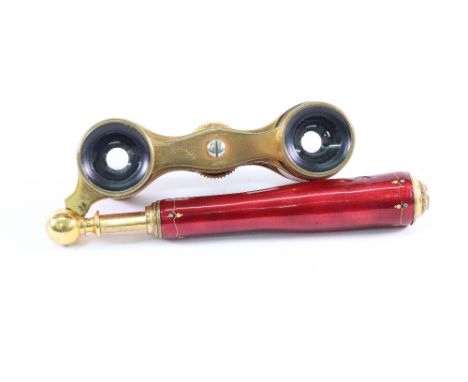 A pair of gilt metal and red guilloche enamel opera glasses, circa 1920, with 'jewelled' ornament, round tapering hinged hand