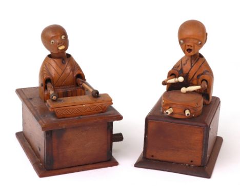 Two carved wooden Japanese Kobi toys, one playing a drum which, when the handle to rear is turned, moves the arms and protrud