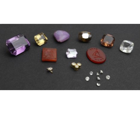 A collection of gem stones, comprising; a round light-brown, mixed-cut tourmaline; a gold and small diamond trefoil; a small 