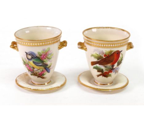 A pair of Royal Worcester two-handled cups and fixed stands, 1870's, each painted each side with a bird in branches beneath a
