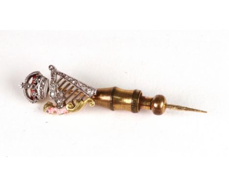 A gold diamond and enamel stick pin, circa 1900, modelled as a crowned harp, 3.3g gross.