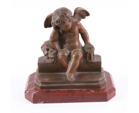 A French late 19th century bronzed figure of a cherub, one arm resting on a skull, seated on a step, on a rouge royale marble