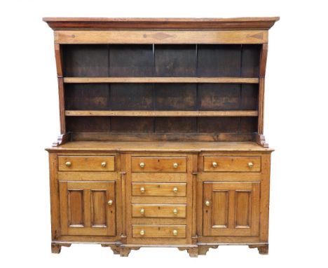 A George III oak and mahogany dresser, the boarded shelved rack with a lozenge, triangular and roundel decorated frieze, the 