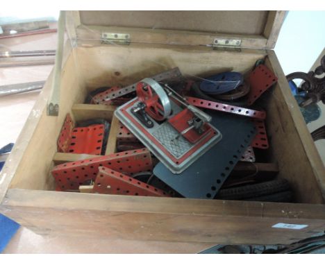 A wooden box of vintage meccano