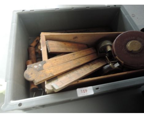 A box of vintage tools including brass plated spirit levels, rules bradawls