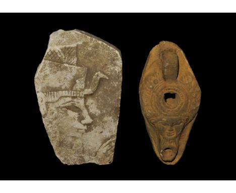 20th century AD. A mixed pair comprising: a ceramic oil lamp with mask of Bes above the nozzle; a limestone plaque with profi