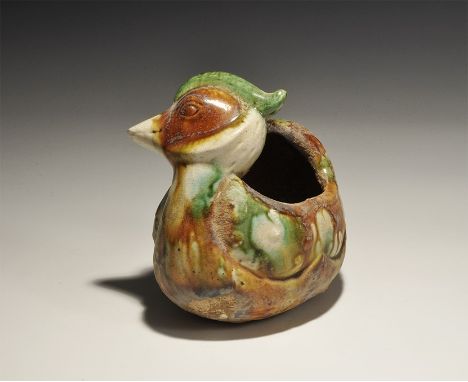 An undated archaistic white-glazed ceramic duck with open back, patched of green and ochre glaze. 369 grams, 13.5cm (5 1/4").