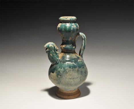 An undated archaistic green-glazed ceramic jug with tall balustered neck, strap handle, spout formed as a bird's head. 593 gr