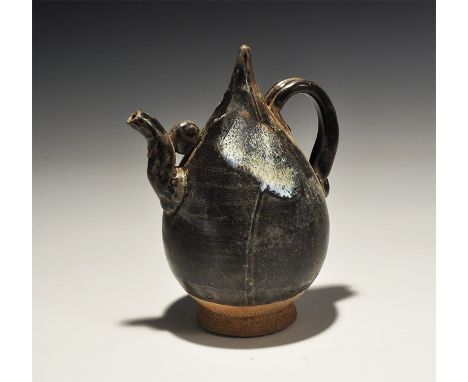 An undated archaistic ovoid glazed ceramic body with conical point, ribbed strap handle to the reverse, short S-curved applie