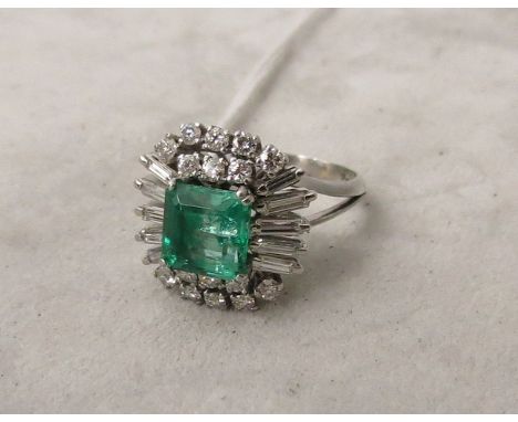 An emerald and diamond cluster ring