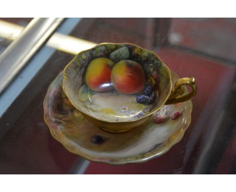 A Royal Worcester teacup and a saucer, painted with Autumnal fruit and signed by W. H. Austin and T. Lockyear, date code for 