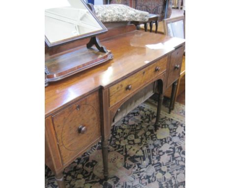 A George IV mahogany breakfront sideboard, with one central drawer flanked by two deep drawers on ring turned tapering legs 9