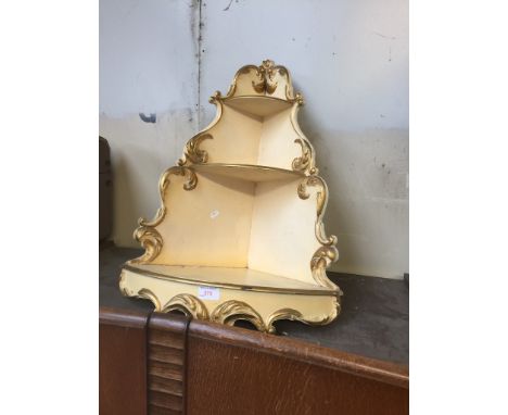 A FRENCH STYLE CREAM AND GOLD PAINTED CORNER SHELF