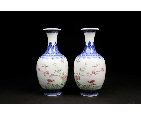 A pair of Chinese Famille rose vases, the neck painted with a band of ruyi heads above a shoulder of bladed leaves, the body 