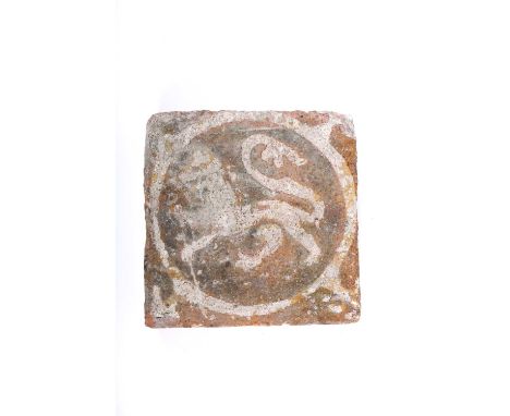 A medieval encaustic tile, 13th century, decorated in off white slip on a terracotta ground, a lion passant facing left withi