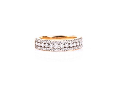 A three row diamond ring, the central band of round brilliant cut diamonds flanked with rows of smaller round brilliant cuts,