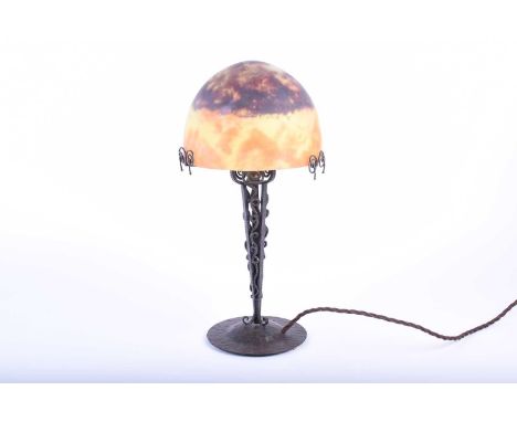 A Secessionist wrought iron table lamp with hand worked metal base, signed Pierre Maynadier, with a frosted glass shade signe