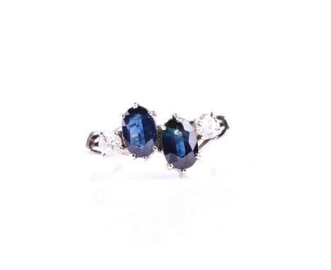 A sapphire and diamond four stone ring, the oval cut sapphires in six claw mounts each with an off-set round brilliant cut di