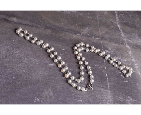 A French platinum and pearl necklace, the pearls set between trace links, 42cm long.Condition report: pearls appear to be nat