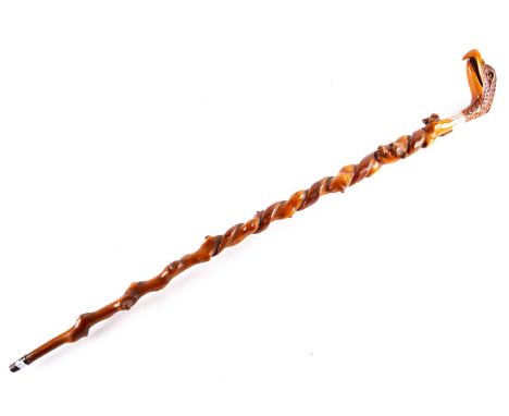 A 19th century carved wood eagle head walking stick, the well carved feathered head forming the grip, with inset orange glass