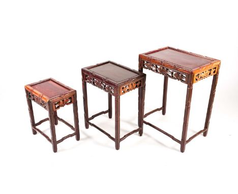 A nest of three Chinese hardwood tables, early 20th century, each of rectangular form with recessed top framed by simulated b