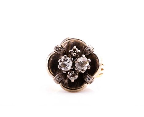 A diamond cluster ring, the white metal mount of quatrefoil design, inset with two old-cut diamonds of approximately 0.20 car