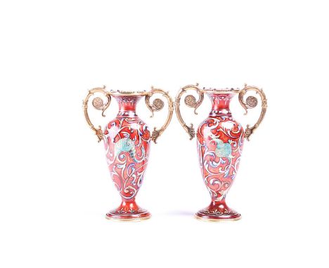 A pair of Russian enamel silver gilt vases, the rims set with diamonds between gilt scroll handles, the ovoid bodies decorate