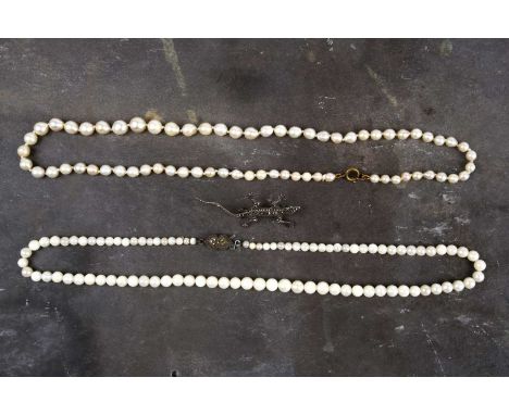 A graduated cultured pearl necklace with base metal clasp, together with another similar, and a silver and marcasite brooch i