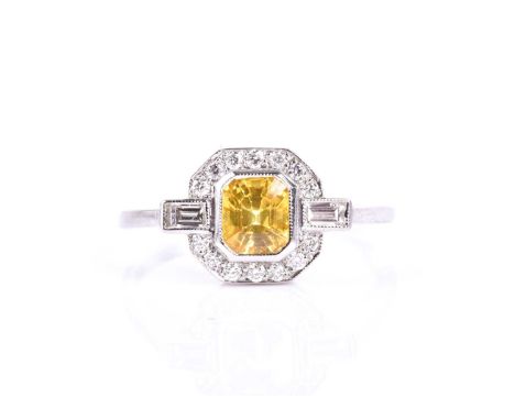 A platinum, diamond, and yellow sapphire ring, set with a mixed rectangular-cut sapphire, within an octagonal border mount of