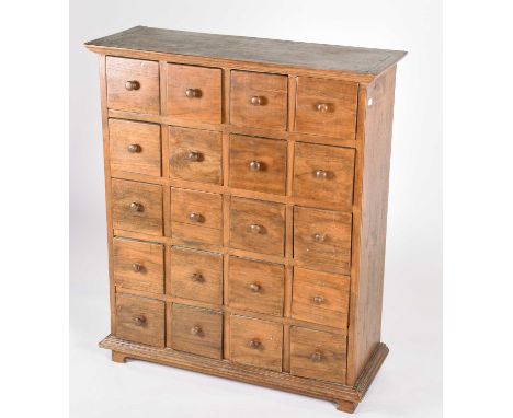 A teak apothecary type chest drawers, the top with applied moulded edge above twenty short drawers with turned knob handles, 