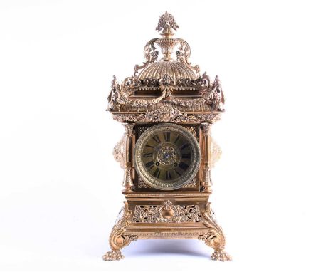 A large and elaborate Victorian brass mantel clock, the dial with Roman numerals and with eight day movement chiming on a sin