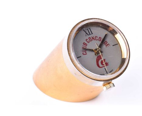 Club Concorde, a novelty desk clock/watch, the sheered cylindrical brass base matt finished, and inset to top with watch, the