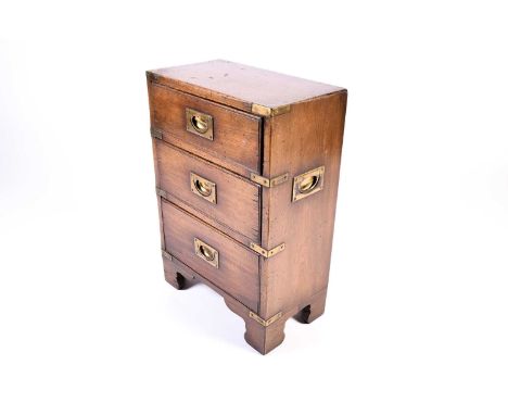 A small late 19th or early 20th century campaign style three-drawer chest, with brass mounts on bracket feet, 60 cm high x 41