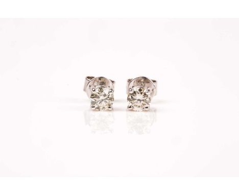 A pair of 18ct white gold and diamond solitaire earrings, the diamonds of approximately 1.0 carats combined, approximate colo