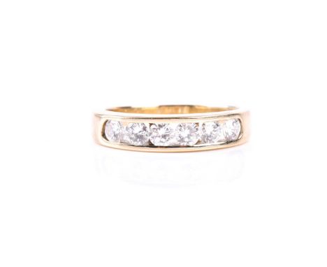 A yellow metal and diamond band ring, channel-set with six round brilliant-cut diamonds of approximately 0.75 carats, shank u