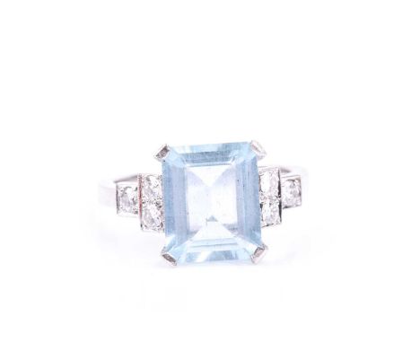 An aquamarine and diamond ring, set with an emerald-cut aquamarine, measuring approximately 9 x 11 mm, flanked with stepped r