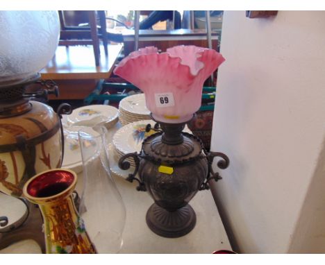 A Victorian oil lamp with Cranberry shade