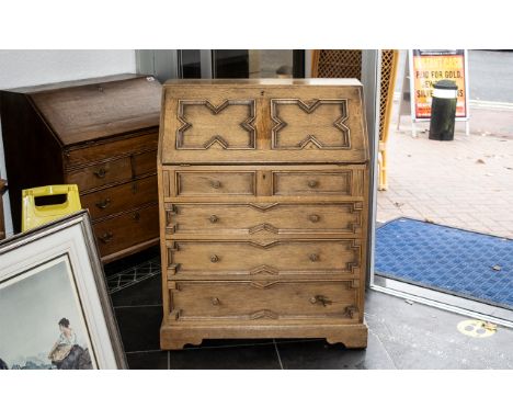 A Modern Light Oak Bureau, fall front above four graduating drawers in a Jacobean style.  Height 38", 30" x 16" deep.