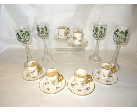 A set of six Limoges Coffee Cans and Saucers of moulded and floral design, with gilt loop handles and a set of four wine glas