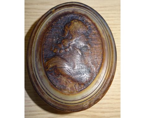 A horn oval Snuff Box and cover decorated with a pressed profile of an 18th Century mans head and shoulders, possibly of Char