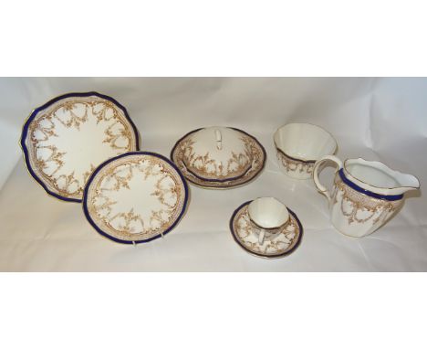 A Royal Crown Derby Tea Set decorated with trailing garlands within a blue and gilt border comprising nine cups and saucers, 