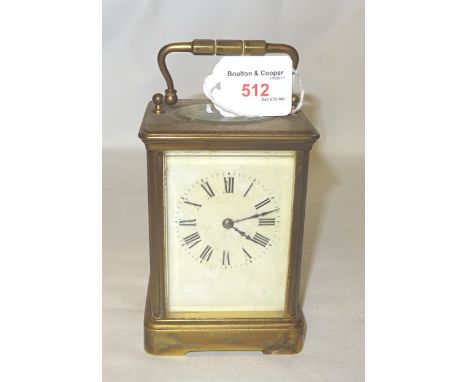 A Carriage Clock with white dial and gong strike in brass and bevelled brass case.  5" (13cms) high.