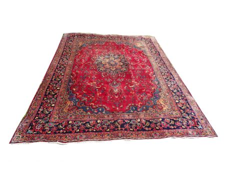 A Meshed Carpet of floral and medallion design on a red field and bordered. 8' 6" (260cms) x 6' 2" (188cms).