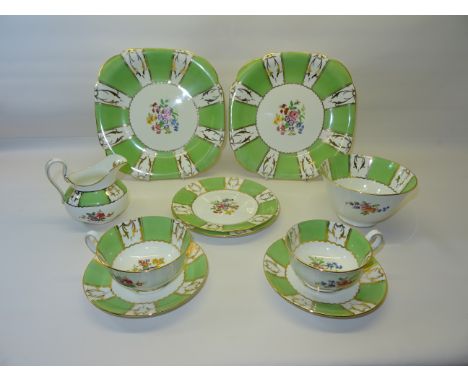 A late Victorian Teaset painted with sprays of flowers within a green and gilt border comprising twelve cups and saucers, twe