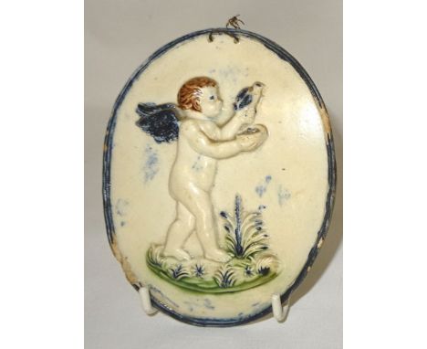 Another Pratt type pearl ware oval Plaque moulded in relief with a figure of an winged cherub holding a bird within a reeded 